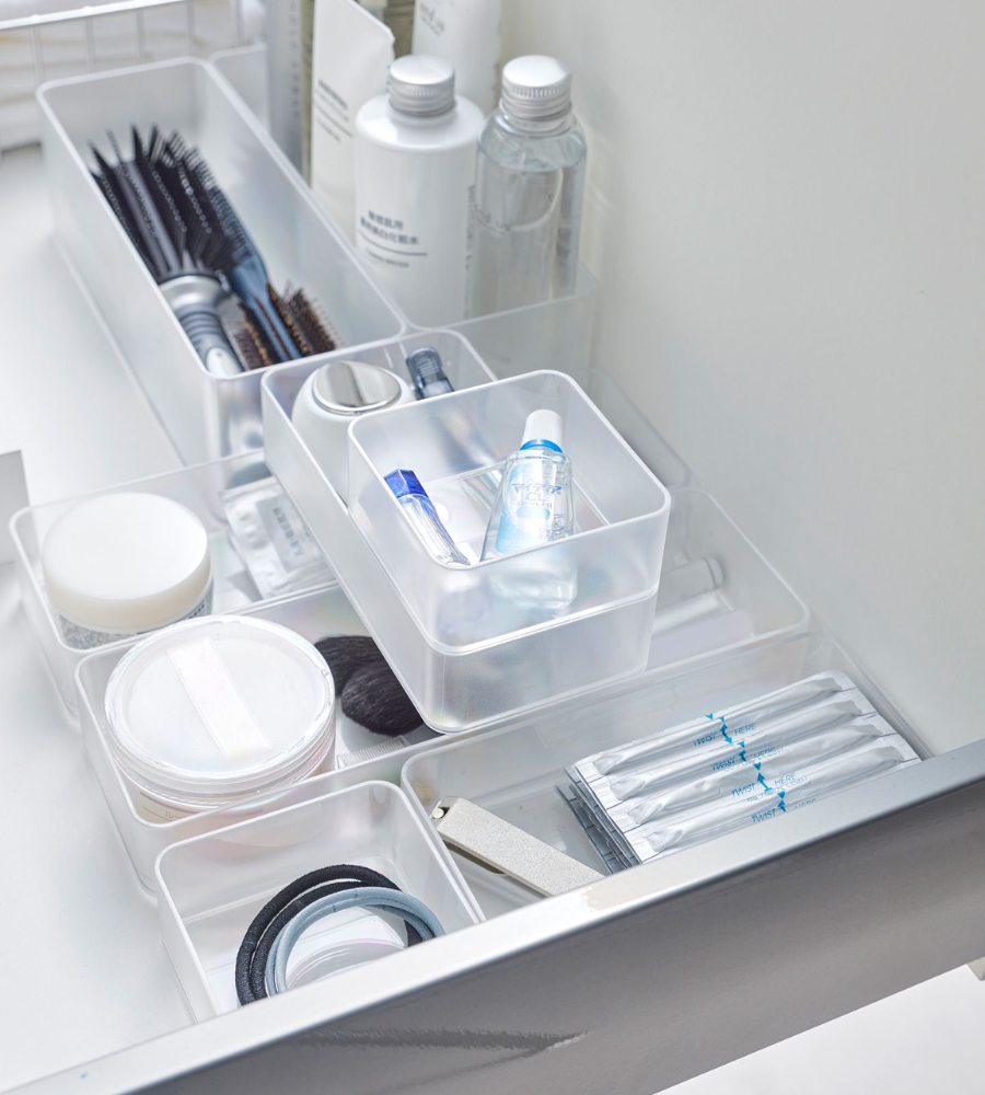 Eine aufgeräumte Schublade mit dem YAMAZAKI TOWER Schubladen Organizer Weiss S (Set 2 Stk.): perfekt für die Aufbewahrung von Toilettenartikeln, Kämmen, Bürsten, Flaschen und Gläsern in separaten Fächern. Hält Wattestäbchen, Rasierklingen und Haargummis geordnet.