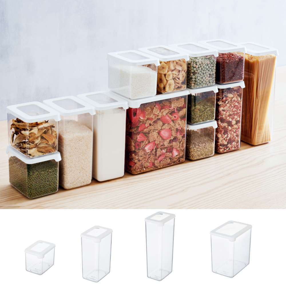 A row of Orthex SmartStore storage jars KLAR - White, filled with pasta, grains, and spices, stands on a light-colored wooden surface. Four empty, stackable containers are displayed underneath.