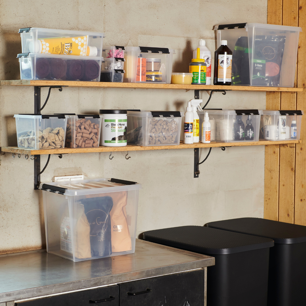 Regale mit Plastikboxen voller Pflegeprodukte und Tierfutter, auf Holzböden in einem Lagerraum.