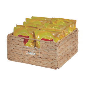 Der iDesign HOME EDIT Etikettenhalter KLAR (Set 3 Stk.) ist ein rechteckiger geflochtener Korb mit der Aufschrift "Snacks", in dem mehrere gelbe Snack-Tüten übersichtlich angeordnet sind. Sein Naturfaser-Look verleiht ihm einen strukturierten Stil.